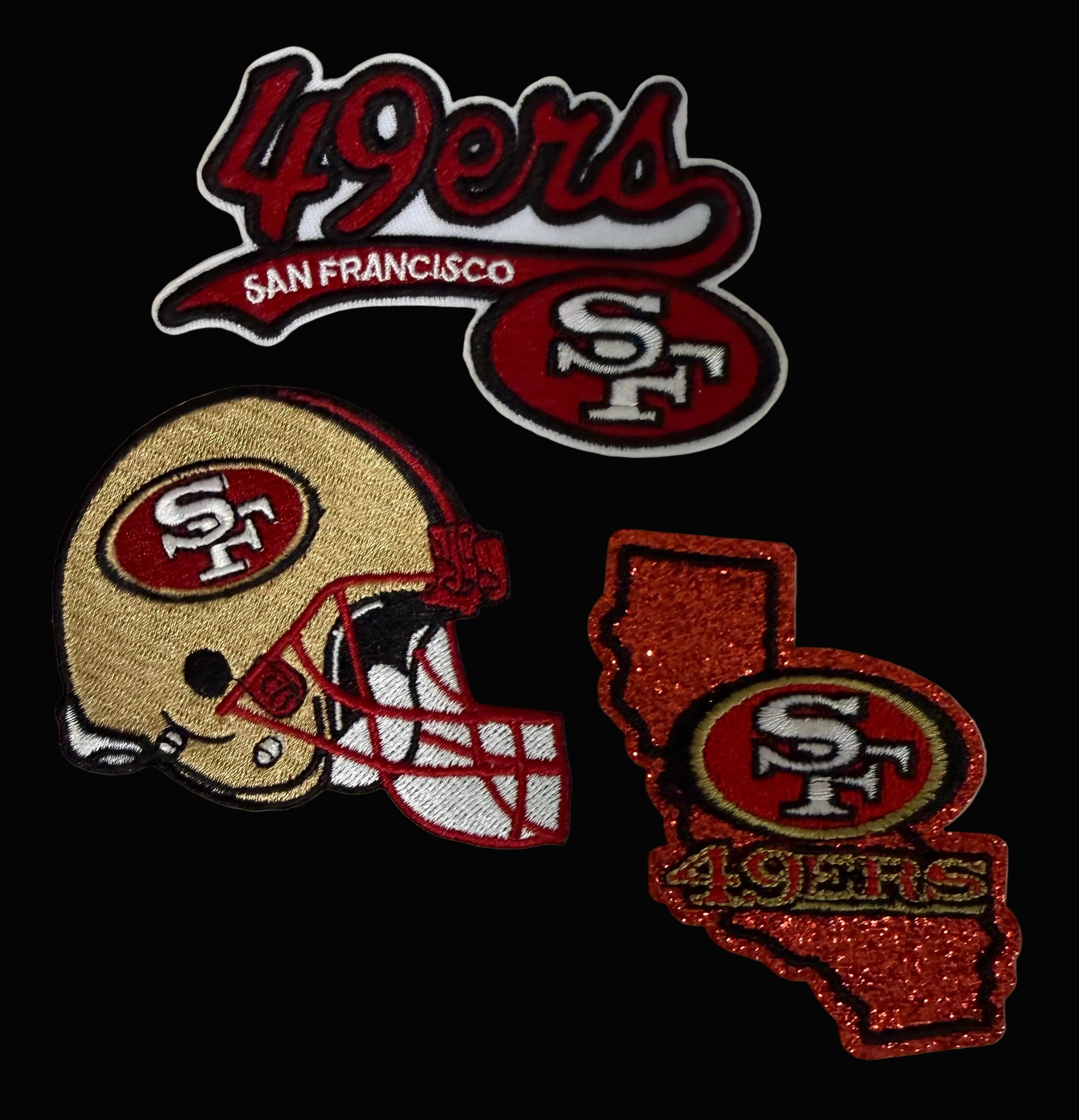 Three San Francisco 49ers embroidered patches on a white fabric background: a '49ers San Francisco' script patch, a football helmet patch, and a glittery California-shaped patch with '49ers' and the SF logo.